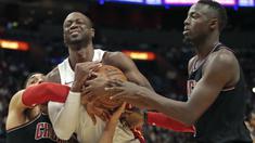Pemain Miami Heat, Dwyane Wade (tengah) berebut bola dengan dua pemain Chicago Bulls pada laga NBA basketball game, di American Airlines Arena, Miami, (29/3/2018). Heat menang 103-92. (AP/Joel Auerbach)