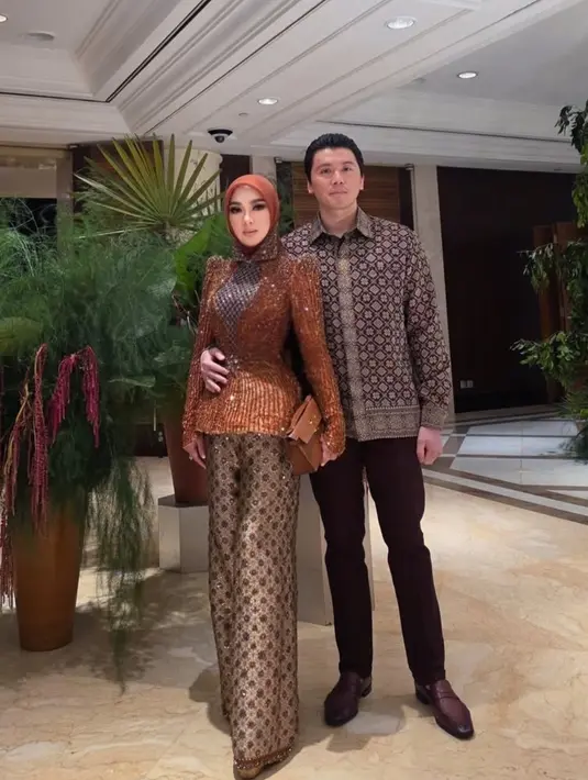 Melengkapi tampilannya dengan selendang warna senada serta mini handbag Hermes coklat. [@princessyahrini]