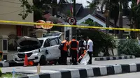 Kondisi mobil berwarna putih yang digunakan terduga teroris setelah serangan di luar markas polisi di Pekanbaru, Riau (16/5). Dalam serangan tersebut satu perwira tewas dan dua lainnya terluka. (AFP Photo/Dedy Sutisna)