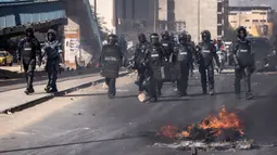 Polisi Senegal berjalan di jalan selama demonstrasi yang diadakan oleh partai-partai oposisi di Dakar pada tanggal 4 Februari 2024. (JOHN WESSELS/AFP)