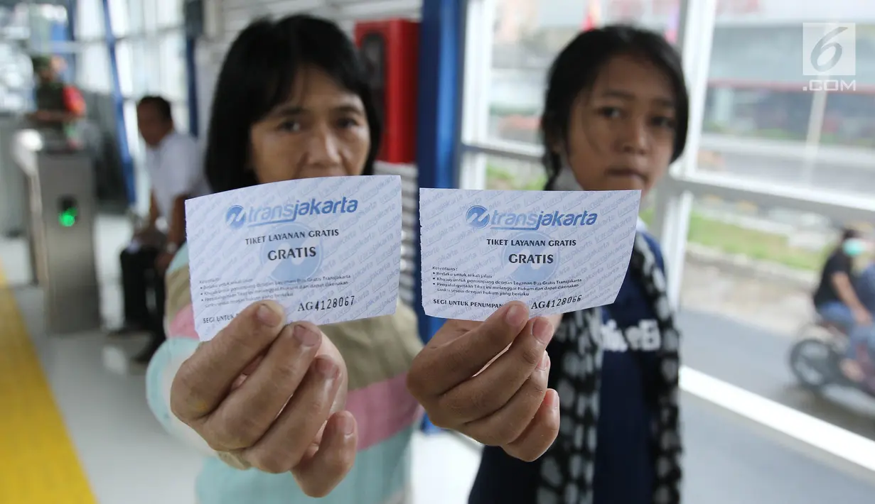 Penumpang menunjukkan tiket sebelum menjajal layanan bus Transjakarta koridor 13 rute Tendean-Ciledug, Jakarta, Minggu (13/8). Hari ini, PT Transjakarta menggratiskan layanan bus Transjakarta yang baru dalam tahap uji coba. (Liputan6.com/Herman Zakharia)