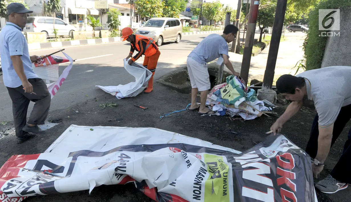 Petugas Bawaslu membersihkan alat peraga kampanye (APK) Pemilu 2019 di kawasan Lebak Bulus, Jakarta Selatan, Minggu (14/4). Pencoptan yang melibatkan tenaga PPSU ini sebagai tindak lanjut masa tenang Pemilu 2019 hingga hari pencoblosan 17 April mendatang. (merdeka.com/Arie Basuki)