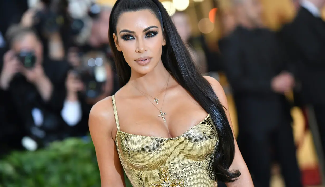 Aktris Kim Kardashian menghadiri Met Gala 2018 untuk pembukaan "Heavenly Bodies: Fashion and The Catholic Imagination" di Manhattan, New York, Amerika Serikat, (7/5). Kim Kardashian tampil seksi mengenakan gaun emas super ketat. (AFP Photo/Angela Weiss)