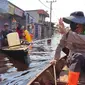 Kapolres Rokan Hilir AKBP Andrian Pramudianto menyapa warga saat memantau banjir. (Liputan6.com/M Syukur)