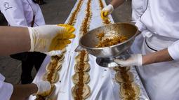 Koki menyiapkan bumbu Taco. Ada sekitar 80.000 Taco yang disusun sepanjang 2,5 km. Pembuatan Taco ini memecahkan rekor dunia versi Guinness, Meksiko, Minggu (15/2/2015).(AFP Photo/Hector Guerrero)