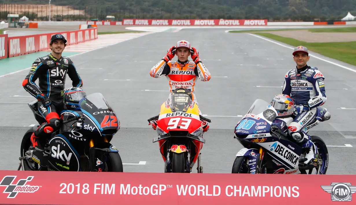 Juara Dunia MotoGP Marc Marquez (tengah) berpose bersama Juara Dunia Moto2 Francesco Bagnaia (kiri) dan Juara Dunia Moto3 Jorge Martin (kanan) usai Grand Prix Valencia di sirkuit Ricardo Tormo, Cheste, Spanyol, Minggu (18/11). (AP Photo/Alberto Saiz)