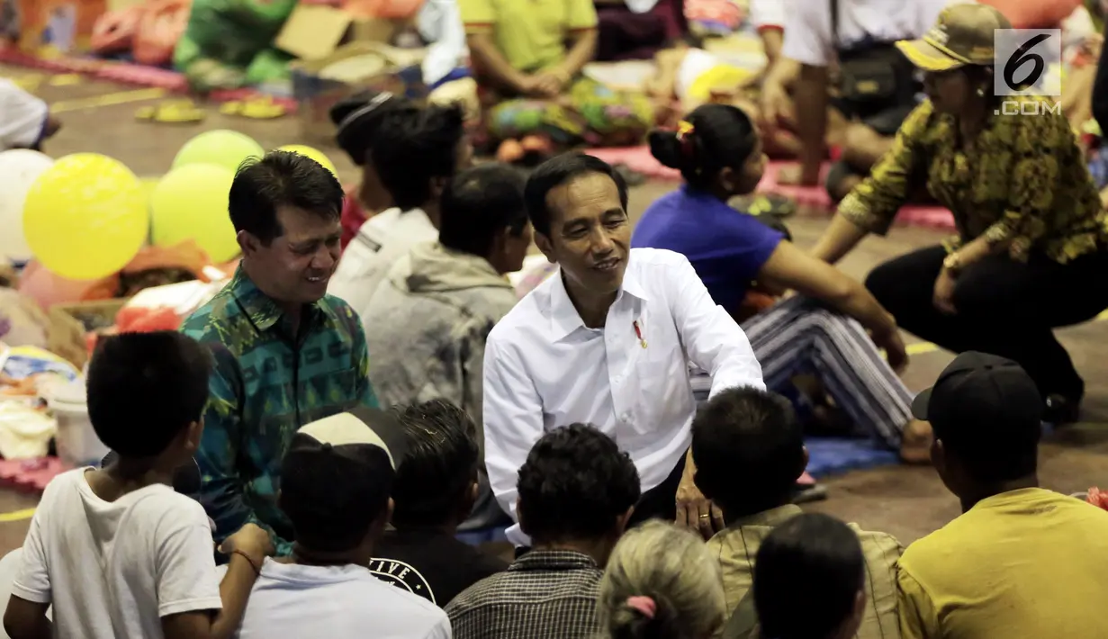 Presiden Joko Widodo atau Jokowi berbincang dengan warga saat berada di lokasi pengungsian Gor Sweca Pura, Klungkung, Bali, Salasa (26/9). Dalam kunjungannya Jokowi memberikan bantuan sebesar 7,1 Miliar. (Liputan6.com/Gempur M Surya)