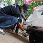 Petugas mengetes gas buang pada kegiatan uji emisi kendaraan di Taman Kota 1 BSD, Tangerang Selatan, Rabu (3/10). Dinas Lingkungan Hidup (DLH) Kota Tangerang Selatan menggelar uji emisi guna menekan angka polusi kendaraan. (Merdeka.com/Arie Basuki)