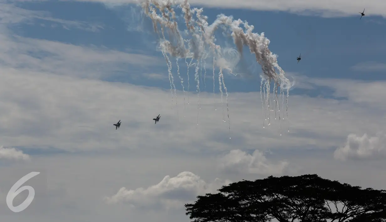Aksi simulasi pesawat tempur menghindari serangan pesawat musuh dalam perayaan HUT TNI Angkatan Udara (TNI AU) ke-71 di Landasan Udara (Lanud) Bandara Halim Perdanakusuma, Jakarta, Minggu (9/4). (Liputan6.com/Faizal Fanani)