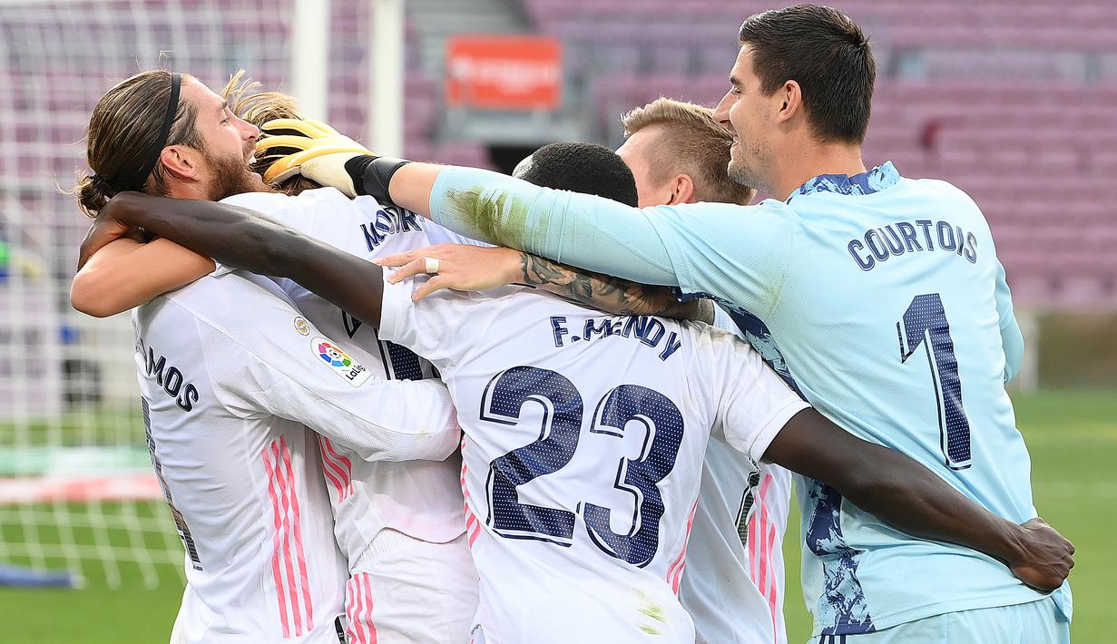 Para pemain Real Madrid merayakan gol ketiganya saat bertandang ke kandang Barcelona pada laga La Liga bertajuk El Clasico di Nou Camp, Sabtu (24/10/2020). Barcelona harus menelan pil pahit kalah 1-3 dari musuh bebuyutannya Real Madrid di kandang sendiri, Nou Camp. (LLUIS GENE/AFP)