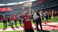 Pemain Manchester United, Sofyan Amrabat mengangkat trofi saat merayakan gelar juara Piala FA 2023/2024 di Stadion Wembley, London, Sabtu (26/05/2024). MU menang dengan skor 2-1 atas Manchester City di partai final. (AFP/Justin Tallis)