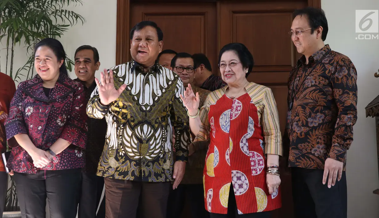Ketua Umum Partai Gerindra Parbowo Subianto (dua kiri) dan Ketua Umum PDIP Megawati Soekarnoputri (dua kanan) melambaikan tangan jelang menggelar pertemuan di kediaman Megawati, Jalan Teuku Umar, Jakarta, Rabu (24/7/2019). Prabowo dan Megawati kompak memakai batik. (Liputan6.com/Helmi Fithriansyah)