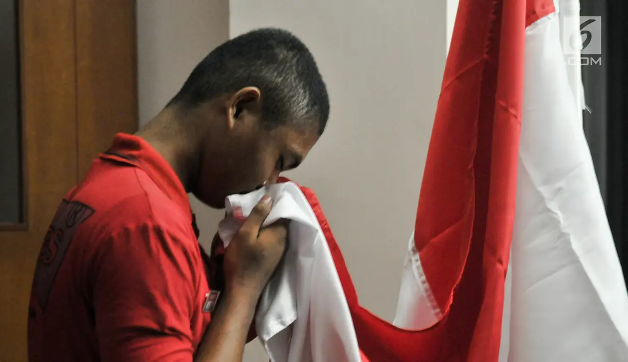 Calon Paskibraka mencium bendera Merah Putih usai mengikuti renungan jiwa di Aula PPPON Cibubur, Jakarta, Minggu (13/8). Malam renungan jiwa sebagai sarana instropeksi diri selama mengikuti pendidikan dan pelatihan. (Liputan6.com/Yoppy Renato)