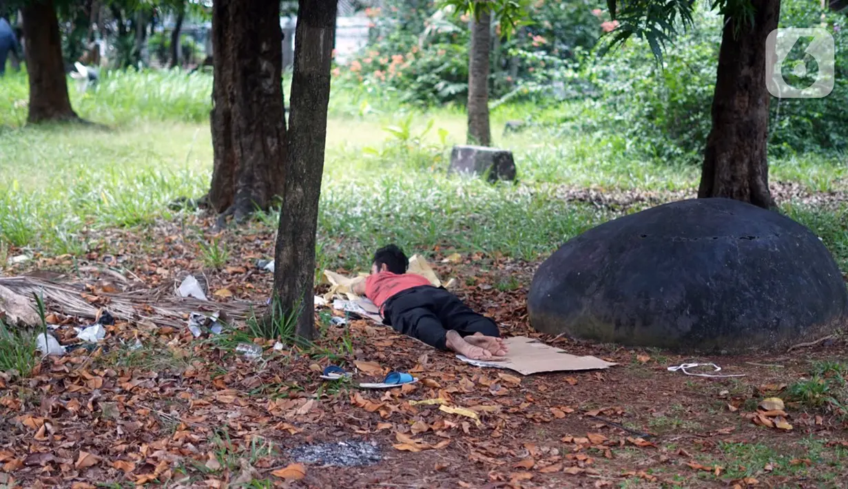 Seorang pria beristirahat di Taman Martha Tiahahu yang terbengkalai di kawasan Blok M, Jakarta Selatan, Selasa (17/11/2020). Taman yang berdiri sejak 1948 tersebut kini kondisinya terbengkalai, dengan sampah dan rumput liar yang tumbuh hampir di seluruh sudut taman. (Liputan6.com/Immanuel Antonius)