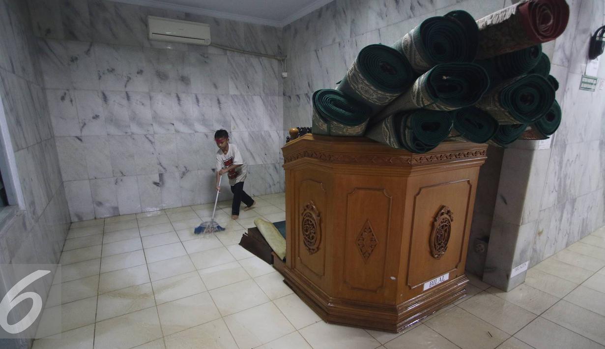 Seorang anak mengeluarkan air saat banjir menggenangi Mesjid An Nur di kawasan Pasar Minggu, Jakarta, Selasa (4/10). Banjir yang rutin menggenangi kawasan tersebut menyebabkan aktivitas warga serta ibadah terganggu. (Liputan6.com/Immanuel Antonius)