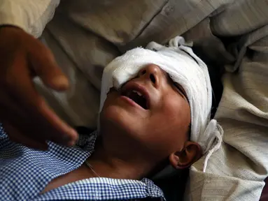 Seorang anak menangis kesakitan karena luka tembak di bagian mata akibat kerusuhan di Srinagar, Kashmir, Kamis (18/8). Sedikitnya lima orang tewas dan 20 lainnya mengalami luka parah akibat bentrok antara warga dan petugas keamanan. (REUTERS)
