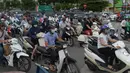 Pengendara motor melintas pada jam sibuk di sebuah jalan pusat kota Hanoi, Vietnam, 4 Juli 2017. Pemerintah melarang sepeda motor masuk kota untuk mengurangi kemacetan dan melipatgandakan armada angkutan publik berbasis bus. (AFP PHOTO/HOANG DINH Nam)