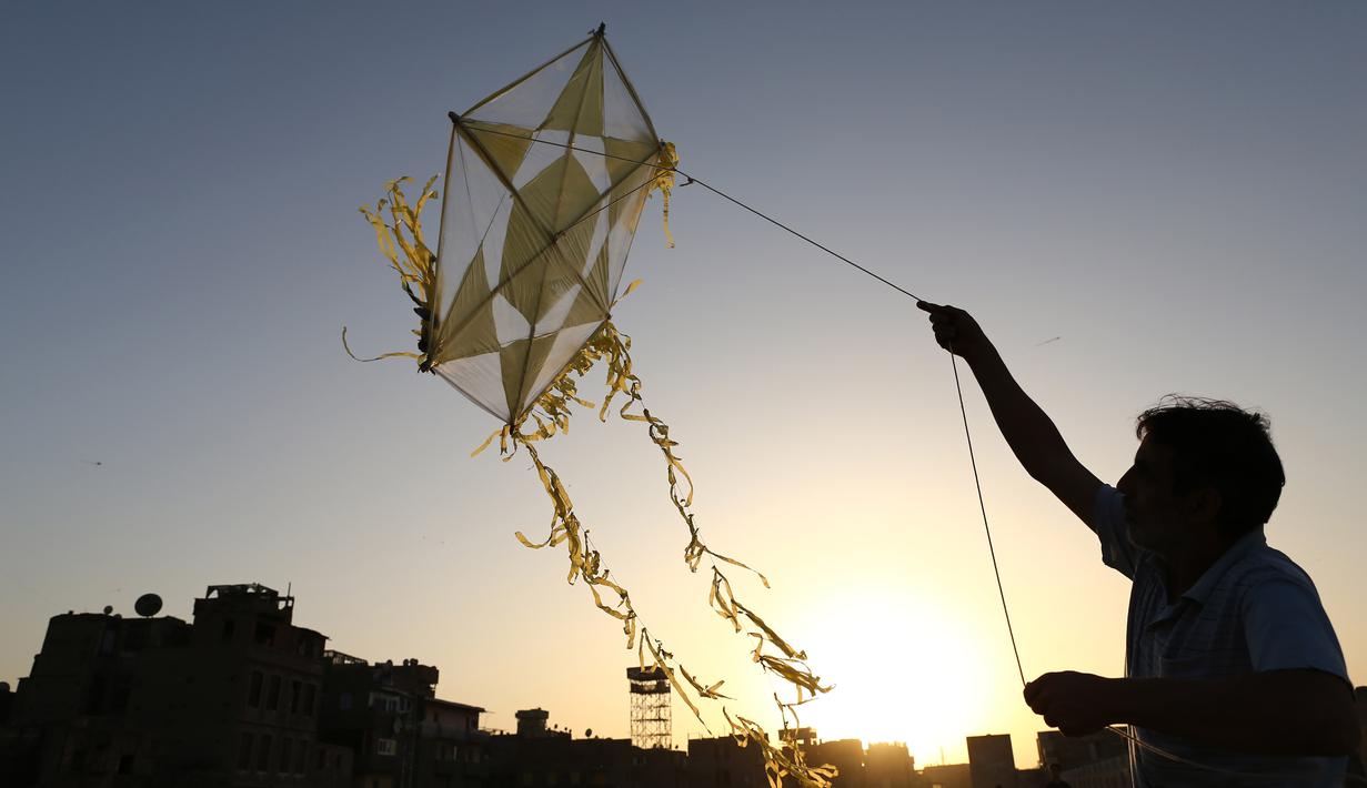 Seorang pria menerbangkan layang-layang di atap sebuah gedung selama masa pandemi COVID-19 di Kairo, Mesir, pada Senin (11/5/2020). Mesir mencatatkan peningkatan harian sebanyak 346 kasus infeksi COVID-19, menambah jumlah kasus terkonfirmasi di negara itu menjadi 9.746. (Xinhua/Ahmed Gomaa)