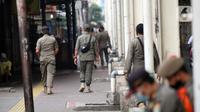Petugas Satpop PP berpatroli di kawasan Pasar Tanah Abang, Jakarta, Rabu (7/7/2021). Satpol PP melakukan penjagaan di seluruh Pasar Tanah Abang mengantisipasi pedagang yang membandel tetap berjualan saat diberlakukannya PPKM Darurat. (Liputan6.com/Angga Yuniar)