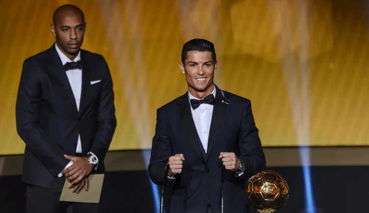 Cristiano Ronaldo (kanan) didampingi Thierry Henry memegang trofi penghargaan Ballon d'Or 2014 di Swiss, Senin (12/1/2015). (AFP PHOTO/Fabrice COFFRINI)