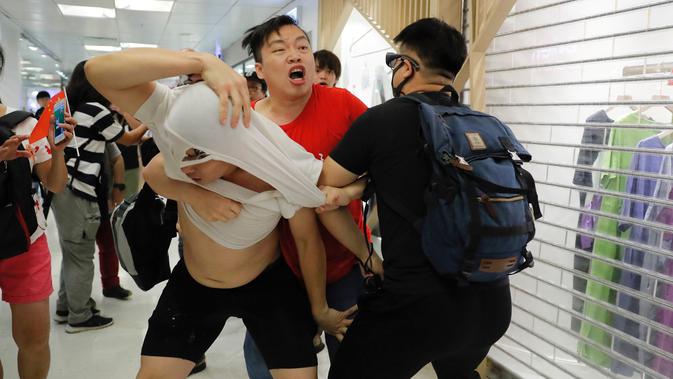 Demonstran pro-China (tengah) berkelahi dengan demonstran antipemerintah di Amoy Plaza, Distrik Kowloon Bay, Hong Kong, Sabtu (14/9/2019). Bentrokan pecah saat demonstran pro-China meneriakkan slogan dukungan untuk polisi. (AP Photo/Kin Cheung)