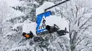 Sebuah rambu jalan tertutup salju di Kocevje, dekat Ljubljana Slovenia, Senin (23/1/2023). Badai salju dengan angin kencang telah menghambat lalu lintas di jalan raya utama di Slovenia pada hari Senin dan menyebabkan beberapa bagian negara tanpa listrik untuk sementara waktu. (AP Photo)