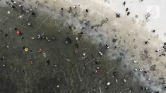 Foto udara menunjukkan keramaian pengunjung saat berenang di Pantai Karnaval Ancol, Jakarta, Jumat (14/5/2021). Pemprov DKI Jakarta pada libur Lebaran 2021 membuka sejumlah tempat wisata, salah satunya Ancol. (Liputan6.com/Johan Tallo)