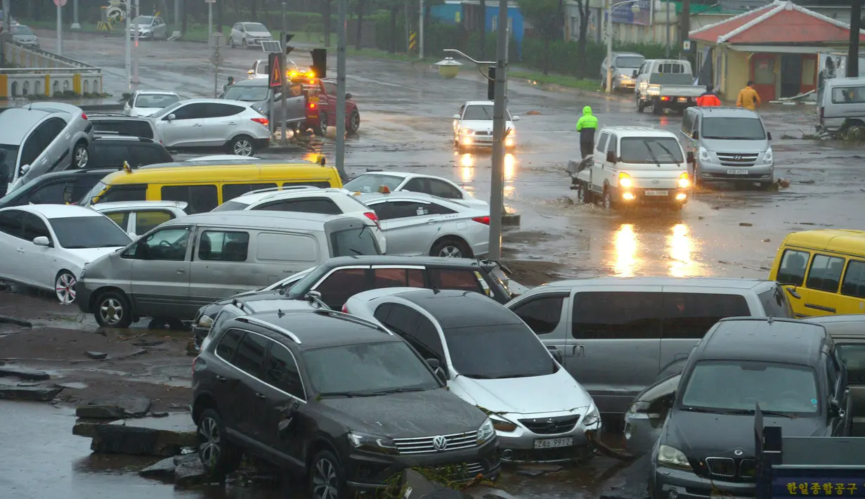 Sejumlah mobil dalam posisi porak-poranda disepanjang jalan setelah hantaman topan Chaba di Pulau jeju, Korsel, Rabu (5/10). Kementerian Keselamatan Publik Korea menyatakan 2.500 sekolah di wilayah selatan negara itu ditutup akibat topan ini. (YONHAP/AFP)