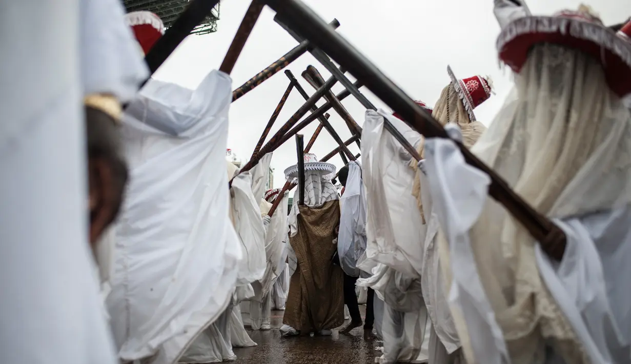 Eyo masqueraders melakukan sebuah gerakan untuk menghibur penonton saat Festival Eyo di Tafawa Balewa Square di Lagos, Nigeria (20/5). (AFP Photo/Stefan Heunis)