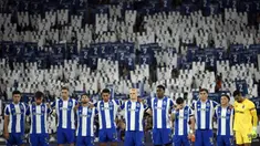 Sejumlah pemain FC Porto mengheningkan cipta dengan latar belakang para penonton yang sedang memegang plakat bergambar nomor punggung dua untuk mengenang kepergian Diogo Costa sebelum laga Liga Portugal 2025/2026 melawan Vitoria Guimaraes SC di Estadio Do Dragao, Porto, Portugal, Senin (11/08/2025) waktu setempat. (AFP/Miguel Riopa)
