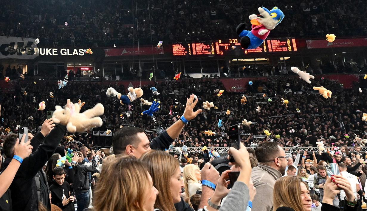 Para penonton melemparkan berbagai macam boneka sebelum laga lanjutan Euroleague Basketball 2024/2025 antara Partizan Belgrade melawan Maccabi Tel Aviv di Belgrade, Serbia, Jumat (03/01/2025) waktu setempat. (AFP/Oliver Bunic)