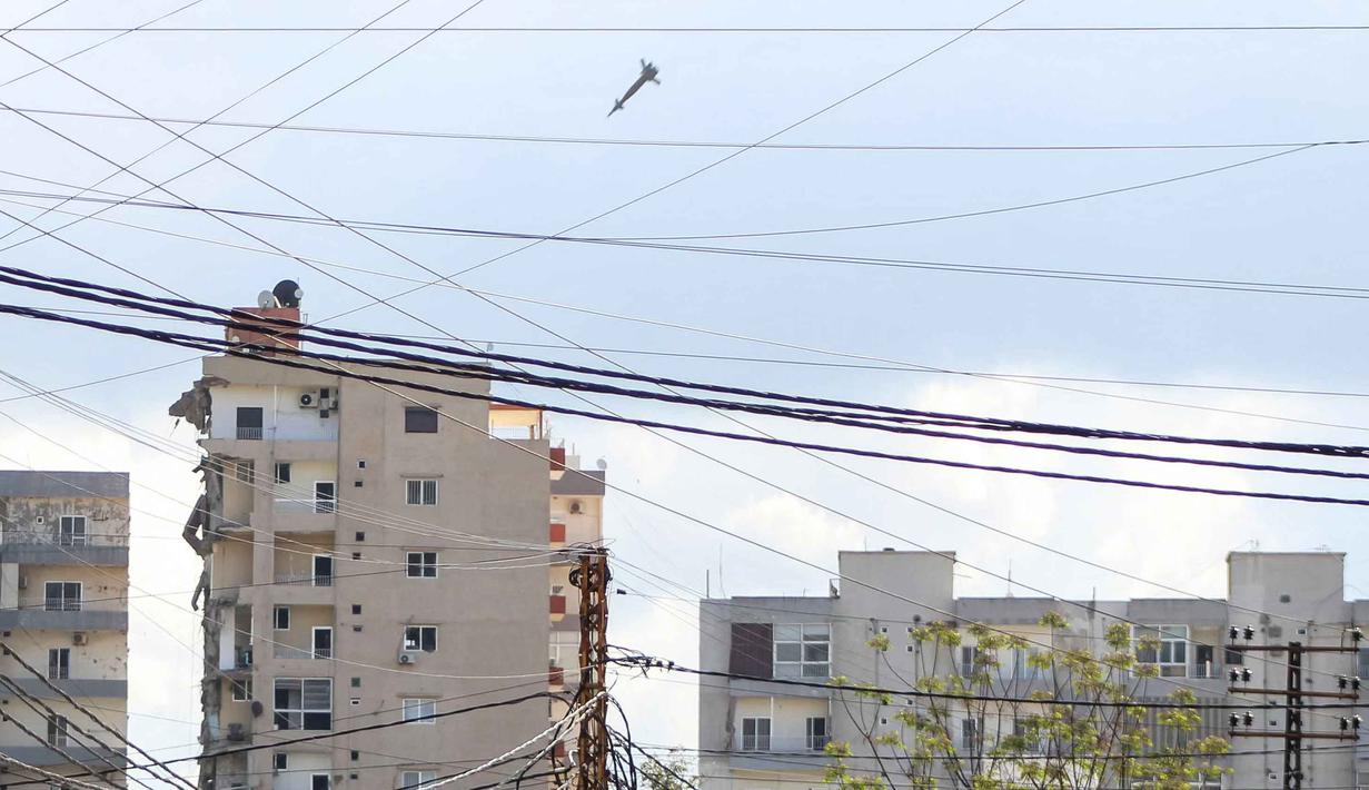 Serangan udara Israel kembali menghantam salah satu bangunan di daerah Abbasiyeh, pinggiran kota Tyre, Lebanon selatan, pada Rabu 8 April 2026. Tampak dalam foto, sebuah proyektil terlihat beberapa saat sebelum menghantam sebuah bangunan selama serangan udara Israel di daerah Abbasiyeh, pinggiran kota Tyre, Lebanon selatan, pada Rabu 8 April 2026. (Kawnat HAJU/AFP)
