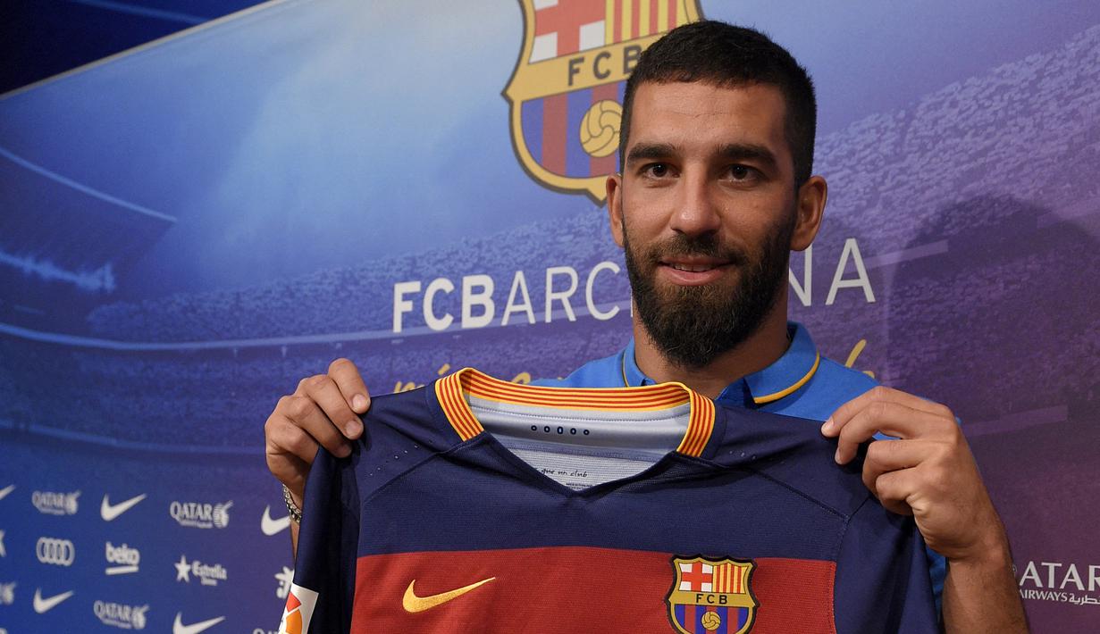 Pemain baru Barcelona, Arda Turan berpose dengan jersey Barcelona saat diperkenalkan secara resmi di Camp Nou Stadium, Barcelona (10/7/2015). Arda Turan didatangkan Barcelona dari Atletico Madrid pada awal musim 2015/2016 dengan nilai transfer sebesar 34 juta euro atau kini setara Rp547 miliar. Bertahan hingga tengah musim 2017/2018 ia total tampil dalam 55 laga di semua ajang dengan torehan 15 gol dan 11 assist. (AFP/Lluis Gene)