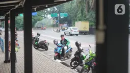 Pengemudi ojek daring menunggu order di depan Cibubur Junction, Jakarta, Selasa (24/3/2020). Merebaknya corona Covid-19 menyebabkan aktivitas di kawasan itu lesu yang juga berimbas pada turunnya pendapatan pengemudi ojol hingga lima kali lipat dibanding hari biasanya (Liputan6.com/Immanuel Antonius)