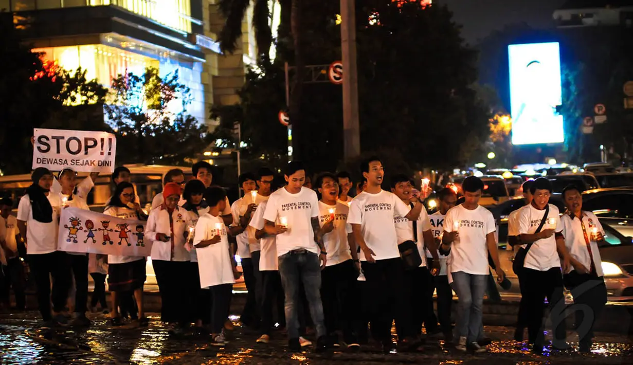 Para peserta aksi mengelilingi Bundaran HI dengan membawa lilin di tangan, Jakarta, Kamis (20/11/2014). (Liputan6.com/Faisal R Syam) 
