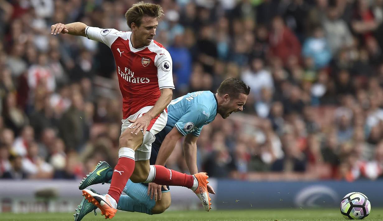 Bek Arsenal, Nacho Monreal, berebut bola dengan gelandang Swansea, Gylfi Sigurdsson, pada laga Premier League di Stadion Emirates, London, Sabtu (15/10/2016). Arsenal menang 3-2 atas Swansea. (Reuters/Hannah McKay)