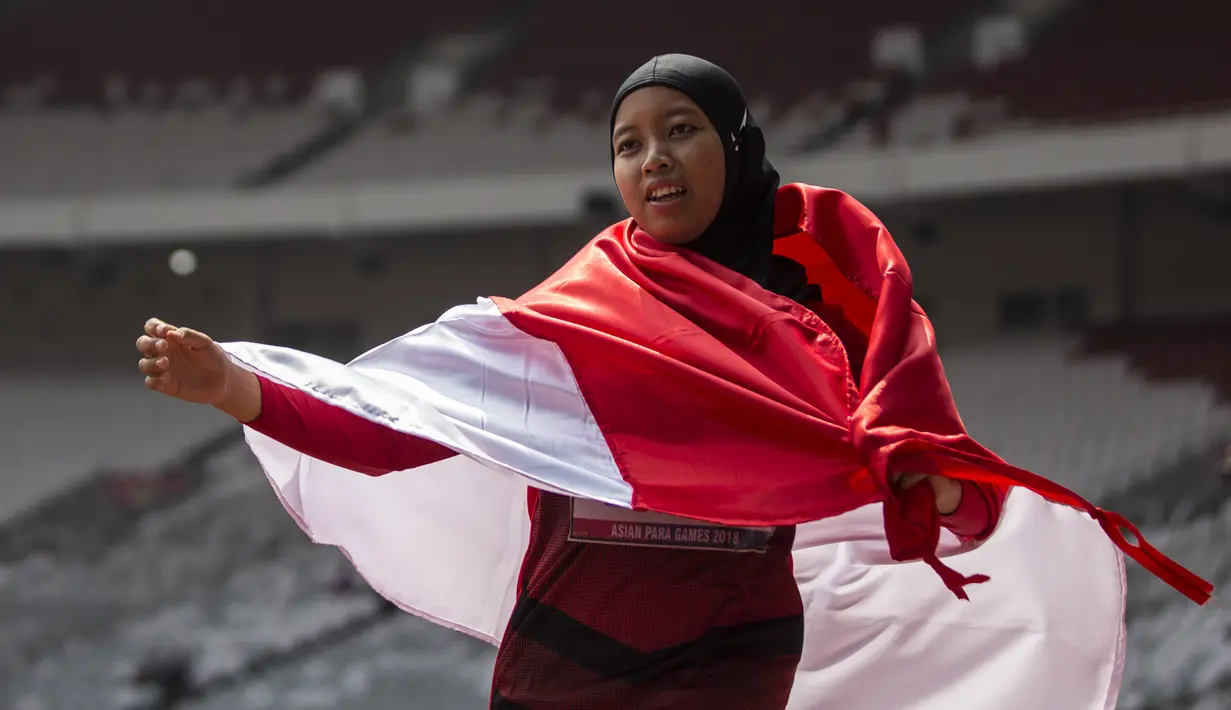 Pelari Indonesia, Tiarani Karisma, melakukan selebrasi usai meraih medali emas Asian Para Games cabang atletik nomor lari 100 meter T42 / T63 di SUGBK, Jakarta, Rabu (10/10/2018). (Bola.com/Vitalis Yogi Trisna)