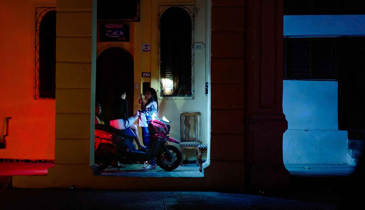 Sejumlah keluarga juga harus beradaptasi dengan kondisi darurat. Tampak dalam foto, orang-orang berkumpul di dekat sebuah bisnis swasta dengan generator listrik selama pemadaman listrik nasional di Havana, Kuba pada 21 Maret 2026. (ADALBERTO ROQUE/AFP)