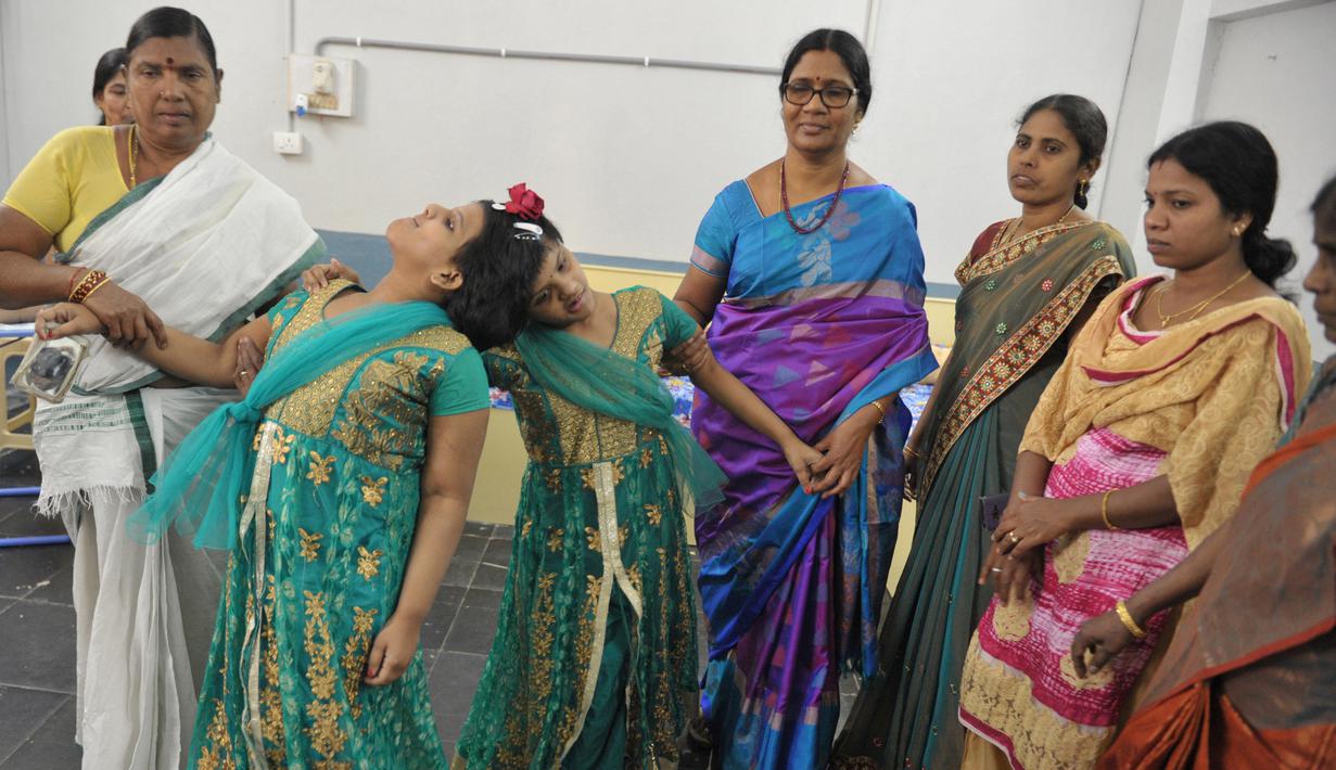 Anak kembar siam, Veena (kanan) dan Vani yang berusia 14 tahun didampingi D. Lalitha Kumari di Rumah Anak di Hyderabad, India (2/1). Sejak kecil, mereka menghabiskan sebagian besar hidup mereka dalam satu kamar. (AFP/Noah Seelam)