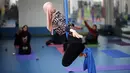 Seorang wanita Palestina melakukan sesi latihan yoga di pusat pelatihan yoga wanita pertama di kota Gaza, 28 Maret 2018. Kelas yoga dengan menggunakan pusat kebugaran darurat ini bertujuan  melatih 32 perempuan sebagai pelatih Yoga. (MOHAMMED ABED/AFP)