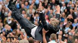 Pelatih Manchester City, Manuel Pellegrini, dilempar ke udara oleh pemainnya saat merayakan gelar juara Liga Primer di Stadion Etihad, Manchester (11/5/2014). (AFP PHOTO/Andrew Yates) 