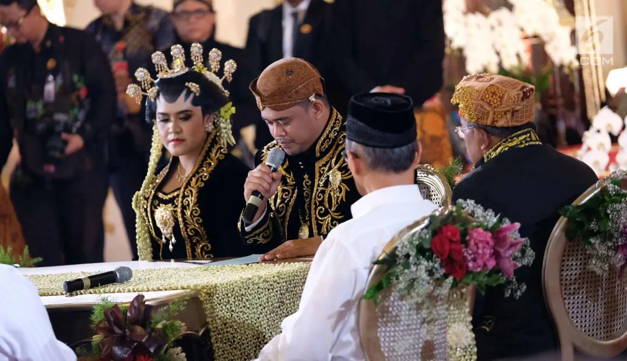 Bobby Nasution disaksikan putri Presiden Jokowi, Kahiyang Ayu membacakan janji nikah setelah melaksanakan ijab kabul di Gedung Graha Saba, Sumber, Solo, Jawa Tengah, Rabu (8/11). (Liputan6.com/Pool/Jimboengphoto)