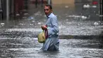 Seorang pria menyeberangi jalan yang tergenang air saat hujan monsun lebat di Rawalpindi, Pakistan, pada 17 Juli 2025. (Aamir Qureshi/AFP)