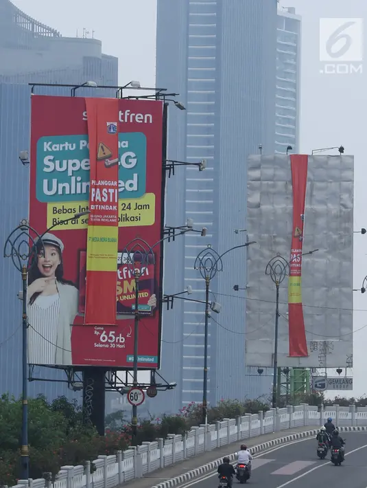 Sejumlah kendaraan melintas di sisi papan reklame di sekitar Jalan HR Rasuna Said, Jakarta, Sabtu (20/12). Pemerintah Provinsi DKI Jakarta akan menurunkan sebanyak 60 papan reklame yang dianggap melakukan pelanggaran. (Liputan6.com/Helmi Fithriansyah)