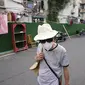 Seorang warga yang mengenakan masker berjalan melewati penghalang di sekitar komunitas di Shanghai (2/6/2022). Lalu lintas, pejalan kaki dan pelari muncul kembali di jalan-jalan Shanghai ketika kota terbesar di China mulai kembali normal di tengah pelonggaran penguncian COVID-19 dua bulan yang ketat atas penerapannya. (AP Photo/Ng Han Guan)