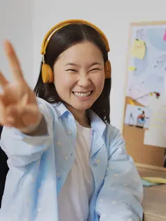 Seorang perempuan sedang berpose sambil mengenakan headphone (Foto Dok: Freepik/freepik).