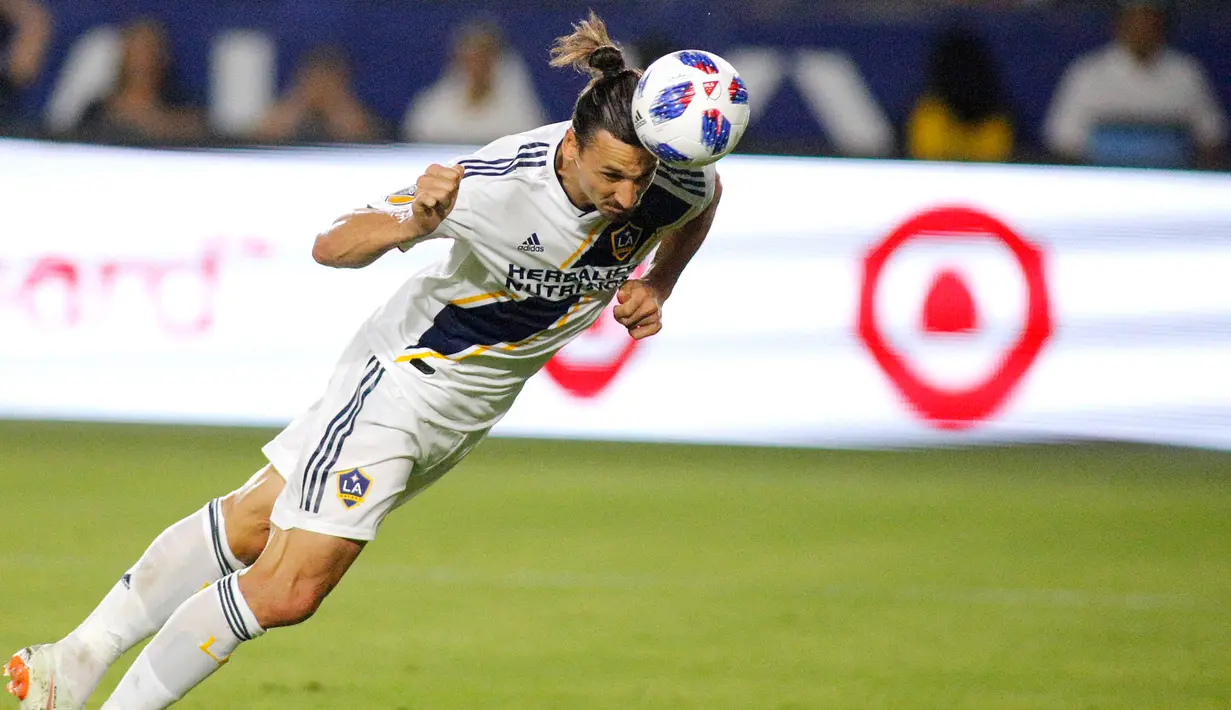 Penyerang LA Galaxy, Zlatan Ibrahimovic saat menyundul bola ke arah gawang kiper Orlando City, Earl Edwards Jr pada pertandingan MLS di StubHub Center di Carson, California (29/7). LA Galaxy menang tipis 4-3 atas Orlando City. (AFP Photo/Katharine Lotze)