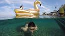Christian Sugiono berenang di dalam air sementara Titi Kamal asyik berada di atas pelampung berbentuk bebek. Foto ini diambil saat Titi dan keluarga kecilnya mengisi liburan di Bali. (instagram.com/titi_kamall)