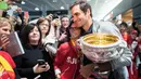 Penggemar wanita berpose dengan Roger Federer yang membawa trofi Australia Terbuka 2018 di Bandara Zurich, di Kloten, Swiss, (30/1). Federer mengalahkan petenis Kroasia Marin Cilic 6-2, 6-7(5), 6-3, 3-6, 6-1. (Ennio Leanza/Keystone via AP)
