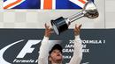 Lewis Hamilton mengangkat trofi juara F1 GP Jepang di Sirkuit Suzuka, Jepang, Minggu (27/9/2015). (AFP Photo/Yuriko Nakao)